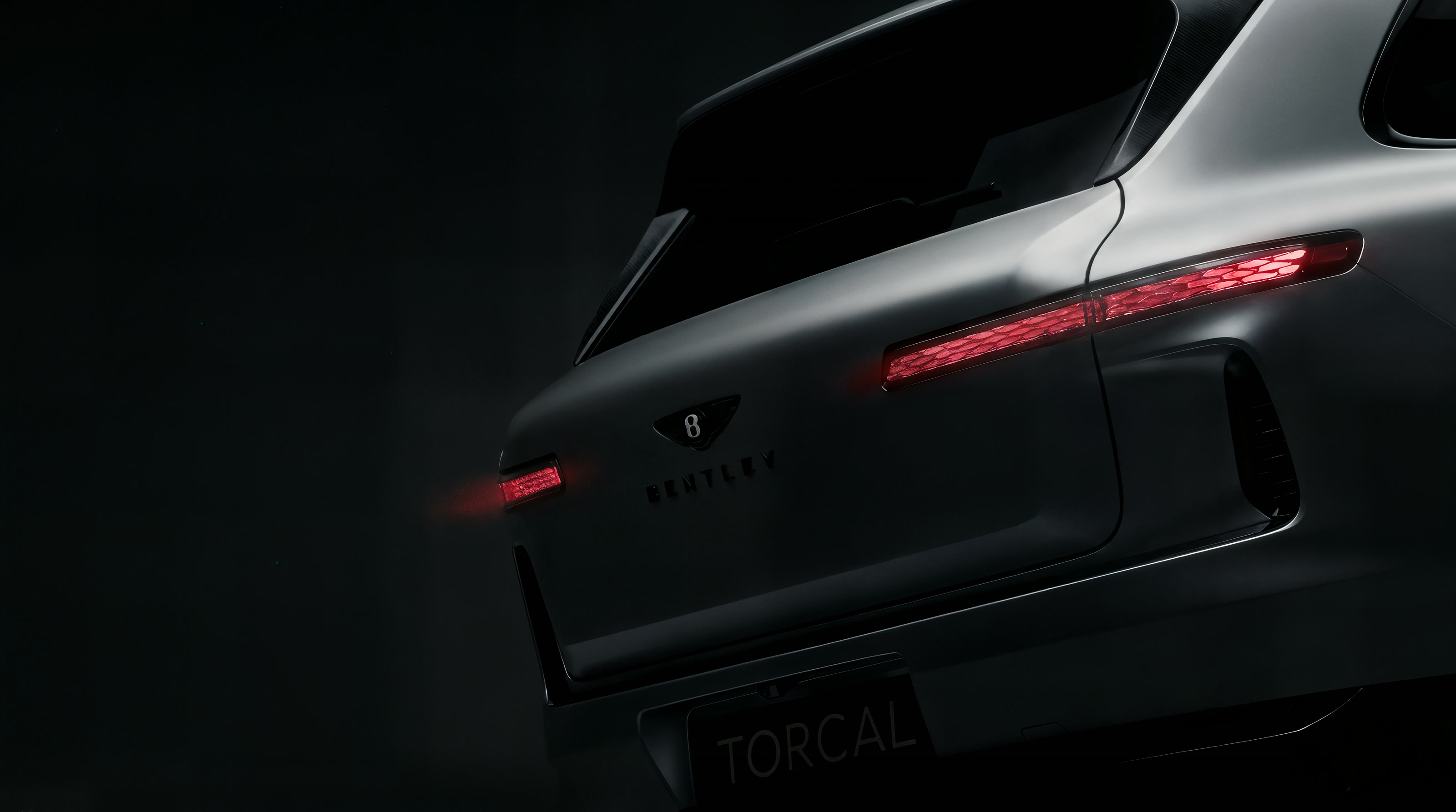 Bentley Torcal concept — matte black tailgate with honeycomb red taillight and TORCAL plate, emerging from darkness